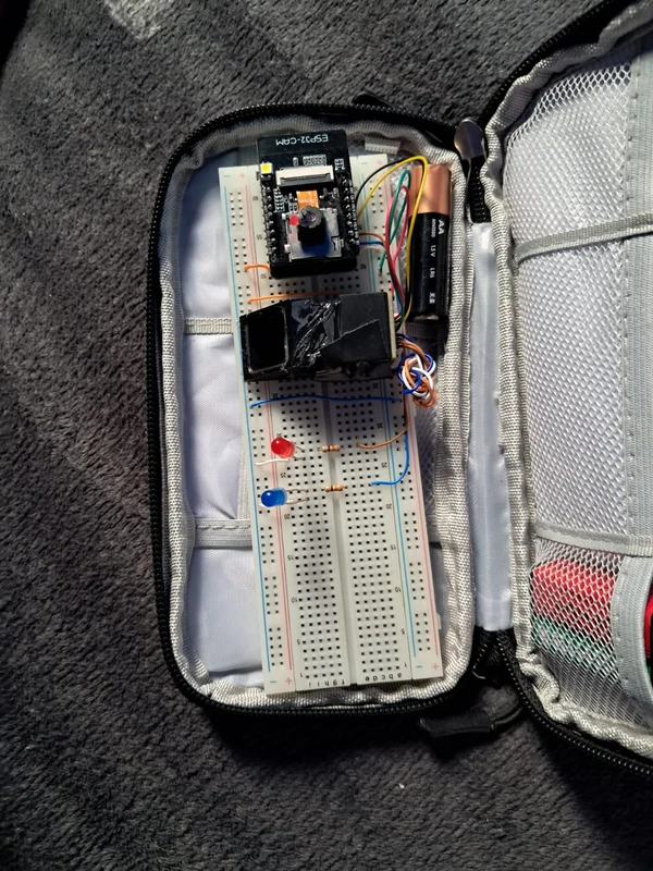 Montaje del proyecto sobre una protoboard dentro de un estuche, con cámara, cables y LEDs.